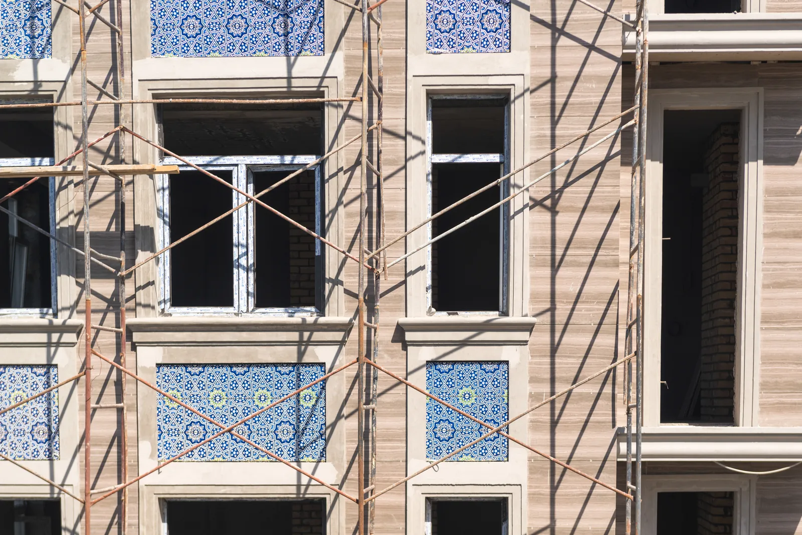 Fachada de prédio de habitação com azulejos e andaime leve durante obras
