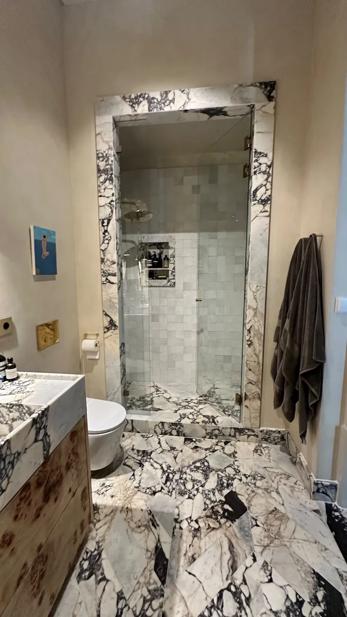 Casa de banho em Alcântara, Lisboa, com duche emoldurado em mármore e móvel em madeira